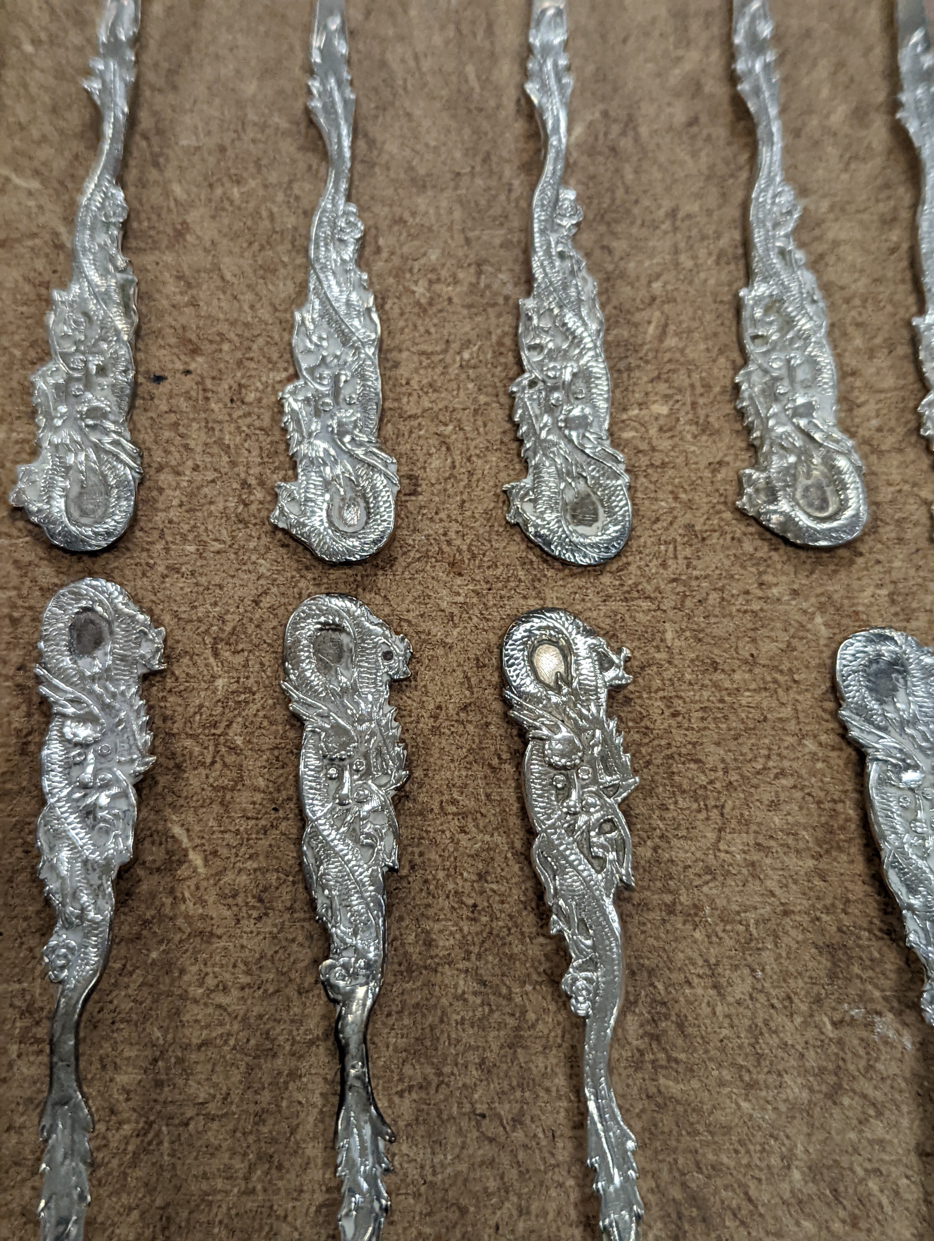 A set of twelve Chinese sterling tea forks, with dragon handles by YCCo and eleven similar teaspoons, 8oz.